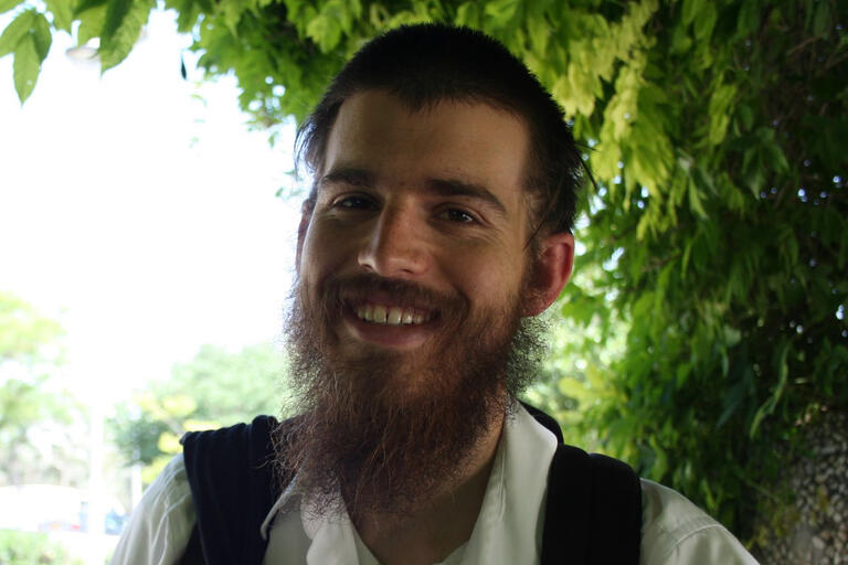 man smiling in front of a tree