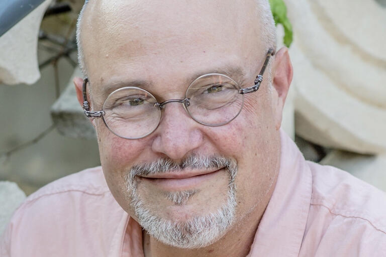 image of man in glasses slightly smiling