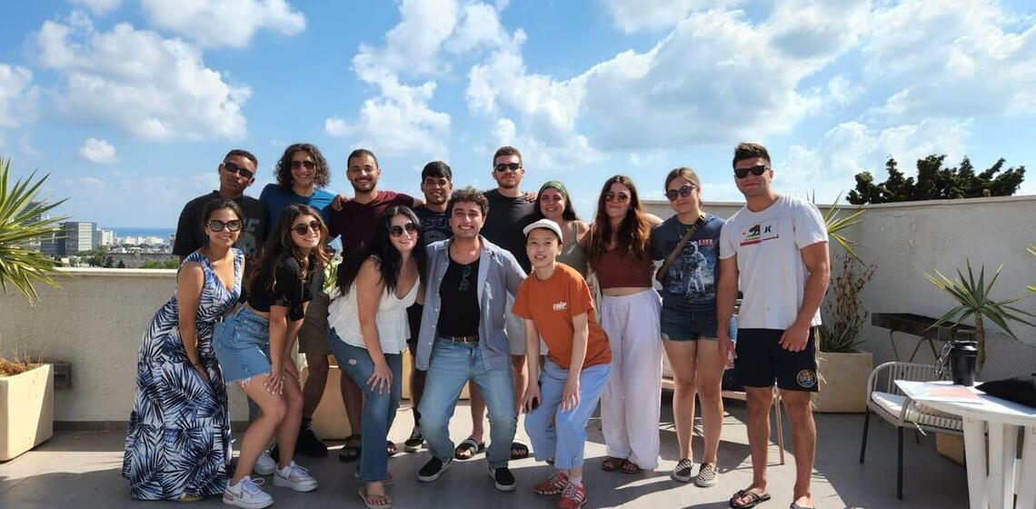 about 20 students standing in front of a vista and smiling