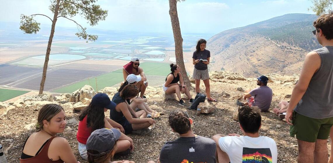 students sitting in a circle on a mountaintop